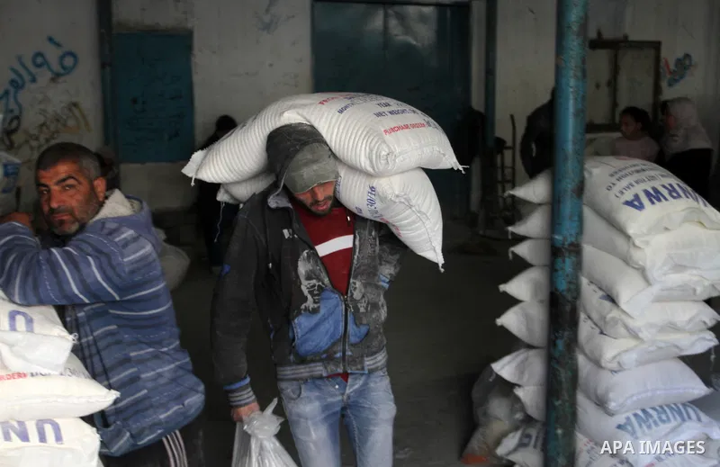 Palestinians receive their monthly food aid at a United Nations distribution center (UNRWA) in the southern Gaza Strip town of Rafah, on January 22, 2017. Photo by Abed Rahim Khatib