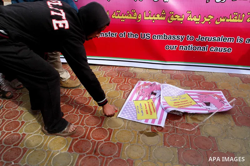 Palestinian protestors burn a placard depicting US President Donald Trump during a demonstration against his pledge to move his country's embassy to Jerusalem, in Rafah in the southern Gaza Strip on January 24, 2017. Tru...