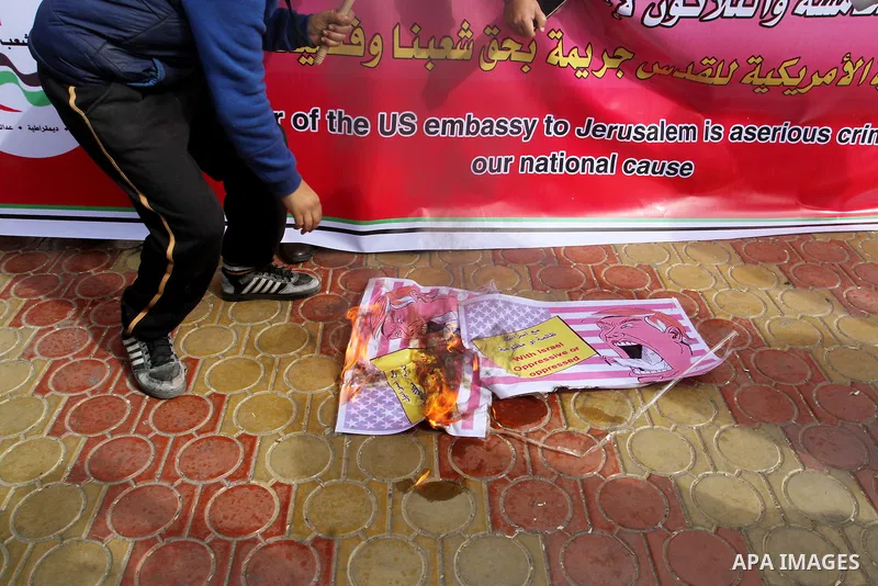Palestinian protestors burn a placard depicting US President Donald Trump during a demonstration against his pledge to move his country's embassy to Jerusalem, in Rafah in the southern Gaza Strip on January 24, 2017. Tru...