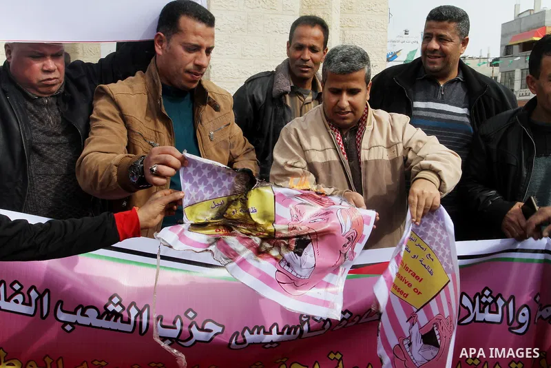 Palestinian protestors burn a placard depicting US President Donald Trump during a demonstration against his pledge to move his country's embassy to Jerusalem, in Rafah in the southern Gaza Strip on January 24, 2017. Tru...
