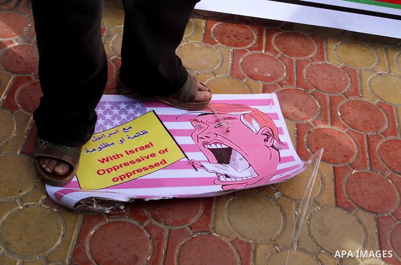 A Palestinian protestor steps on a placard depicting US President Donald Trump during a demonstration against his pledge to move his country's embassy to Jerusalem, in Rafah in the southern Gaza Strip on January 24, 2017...