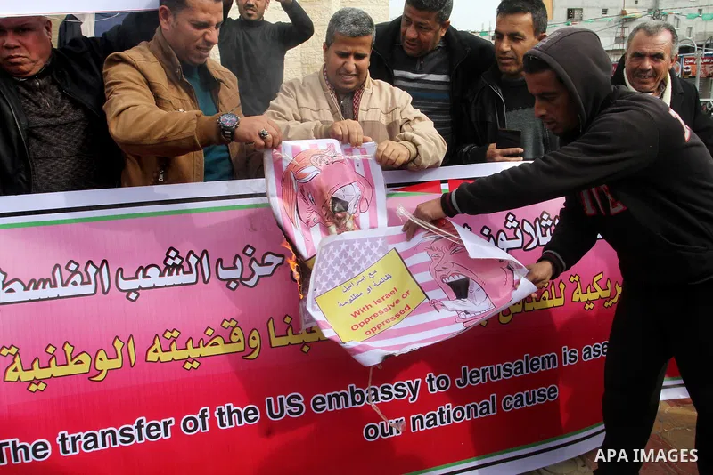 Palestinian protestors burn a placard depicting US President Donald Trump during a demonstration against his pledge to move his country's embassy to Jerusalem, in Rafah in the southern Gaza Strip on January 24, 2017. Tru...
