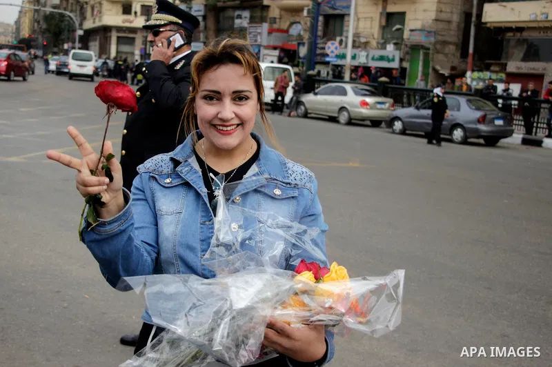 A supporter of Egypt's President Abdel Fattah al-Sisi distributes flowers to policemen marking Police Day, which falls on Jan. 25, and is also the anniversary of the 2011 uprising, in Tahrir Square, Cairo, Egypt, on Janu...