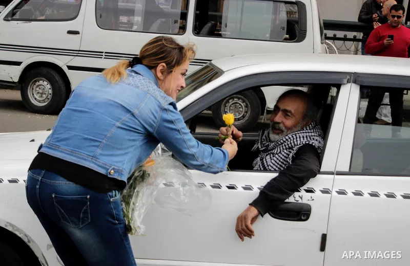 A supporter of Egypt's President Abdel Fattah al-Sisi distributes flowers to passing vehicles marking Police Day, which falls on Jan. 25, and is also the anniversary of the 2011 uprising, in Tahrir Square, Cairo, Egypt,...