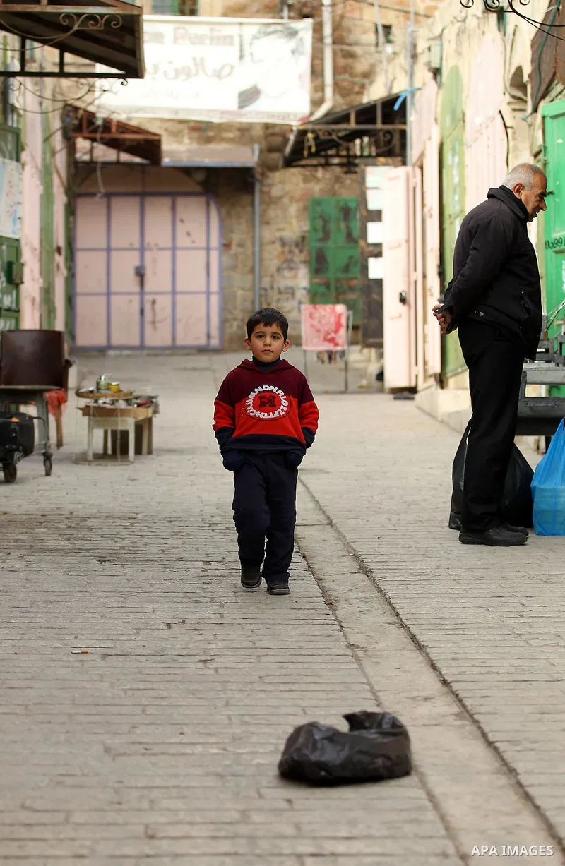 A Palestinian boy walks at a street in the Old City of the West Bank town of Hebron, on January 25, 2017. Photo by Wisam Hashlamoun