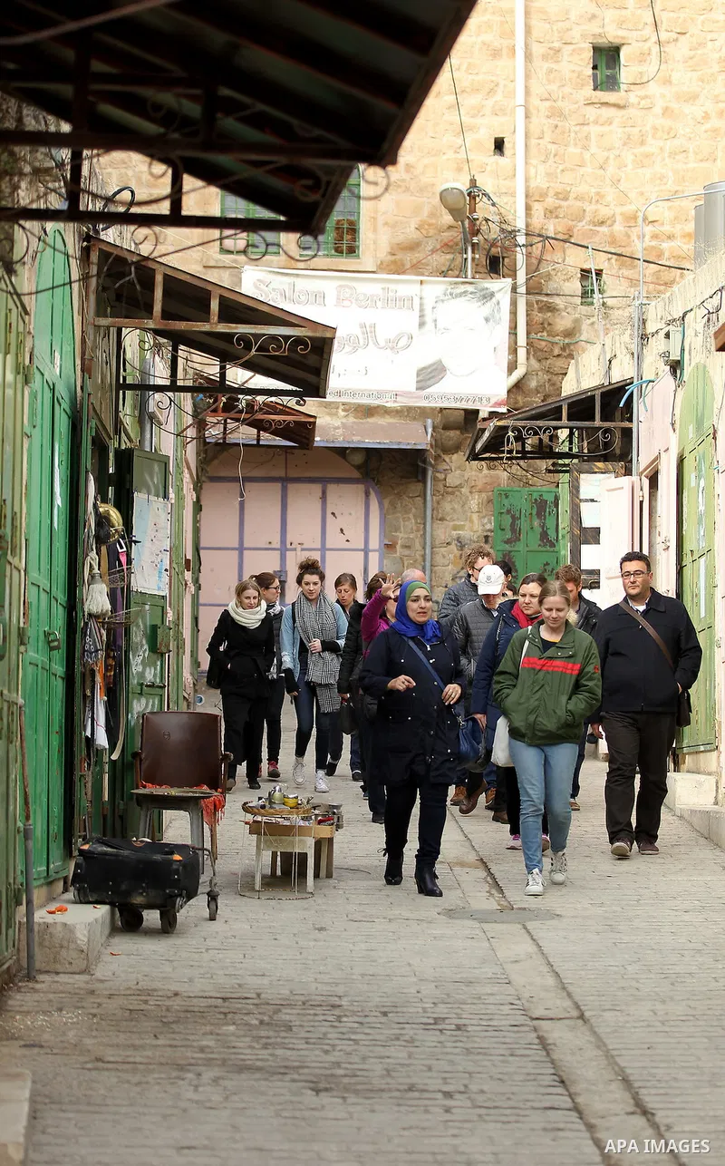 Palestinians walk at a street in the Old City of the West Bank town of Hebron, on January 25, 2017. Photo by Wisam Hashlamoun