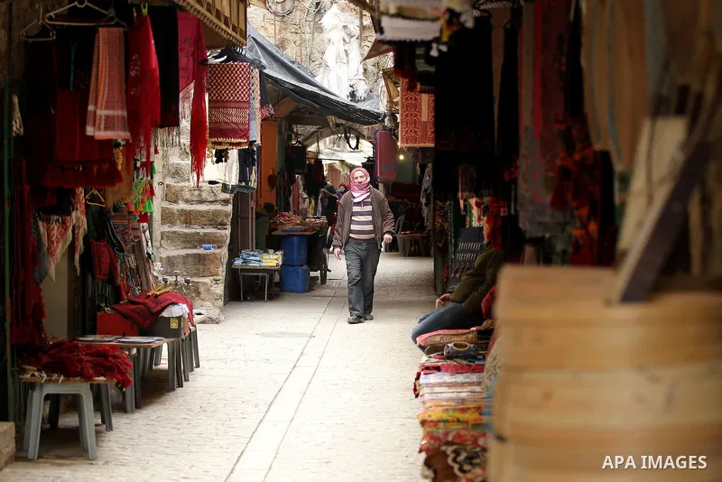 A Palestinian man walks at a market in the Old City of the West Bank town of Hebron, on January 25, 2017. Photo by Wisam Hashlamoun