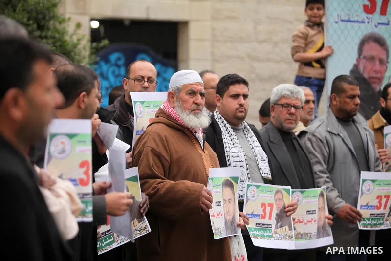 Palestinians hold placards during a protest to show solidarity with Palestinian prisoners in Israeli jails, in front of the high commissioner for human rights headquarters, in Gaza city, on January 26, 2017. Photo by Ash...