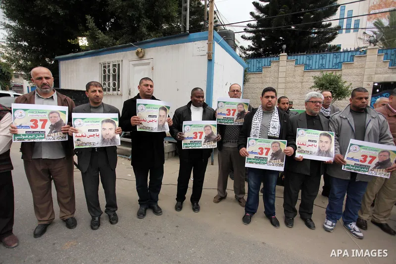 Palestinians hold placards during a protest to show solidarity with Palestinian prisoners in Israeli jails, in front of the high commissioner for human rights headquarters, in Gaza city, on January 26, 2017. Photo by Ash...