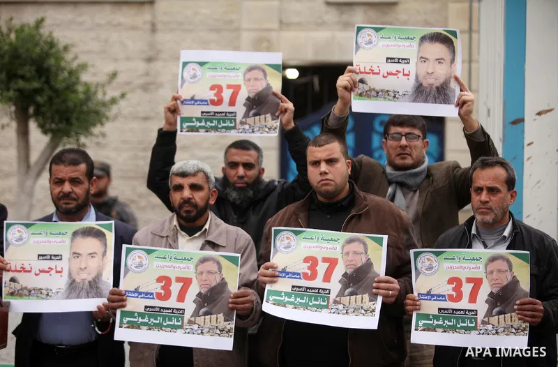 Palestinians hold placards during a protest to show solidarity with Palestinian prisoners in Israeli jails, in front of the high commissioner for human rights headquarters, in Gaza city, on January 26, 2017. Photo by Ash...
