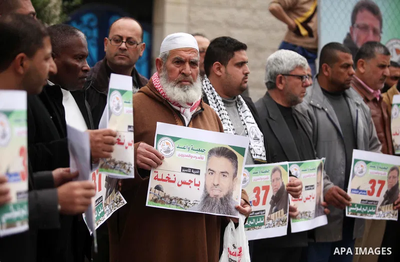 Palestinians hold placards during a protest to show solidarity with Palestinian prisoners in Israeli jails, in front of the high commissioner for human rights headquarters, in Gaza city, on January 26, 2017. Photo by Ash...