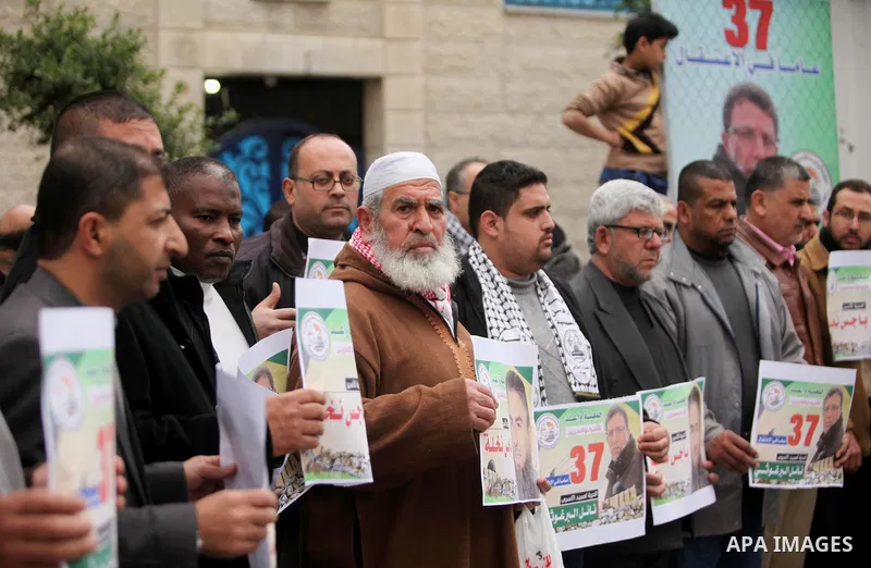 Palestinians hold placards during a protest to show solidarity with Palestinian prisoners in Israeli jails, in front of the high commissioner for human rights headquarters, in Gaza city, on January 26, 2017. Photo by Ash...