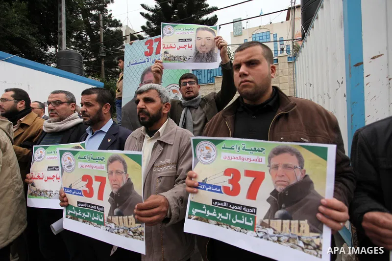 Palestinians hold placards during a protest to show solidarity with Palestinian prisoners in Israeli jails, in front of the high commissioner for human rights headquarters, in Gaza city, on January 26, 2017. Photo by Ash...