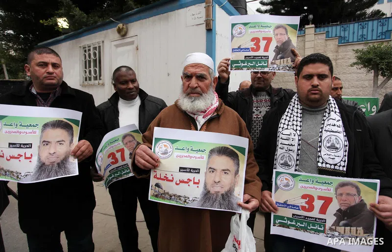 Palestinians hold placards during a protest to show solidarity with Palestinian prisoners in Israeli jails, in front of the high commissioner for human rights headquarters, in Gaza city, on January 26, 2017. Photo by Ash...