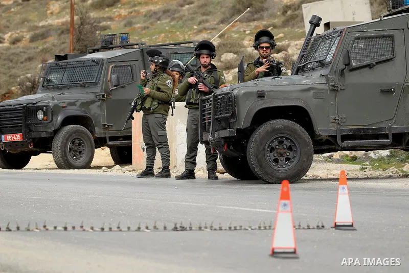 Israeli soldiers stand guard at a checkpoint in the West Bank village of Bani Na'im, near Hebron, on January 26, 2017. Photo by Wisam Hashlamoun