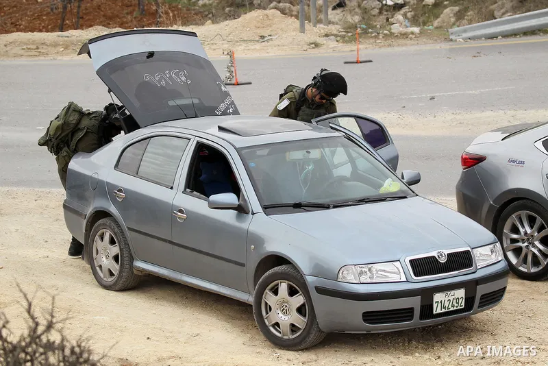 Israeli soldiers check the identity cards of Palestinians at a checkpoint in the West Bank village of Bani Na'im, near Hebron, on January 26, 2017. Photo by Wisam Hashlamoun