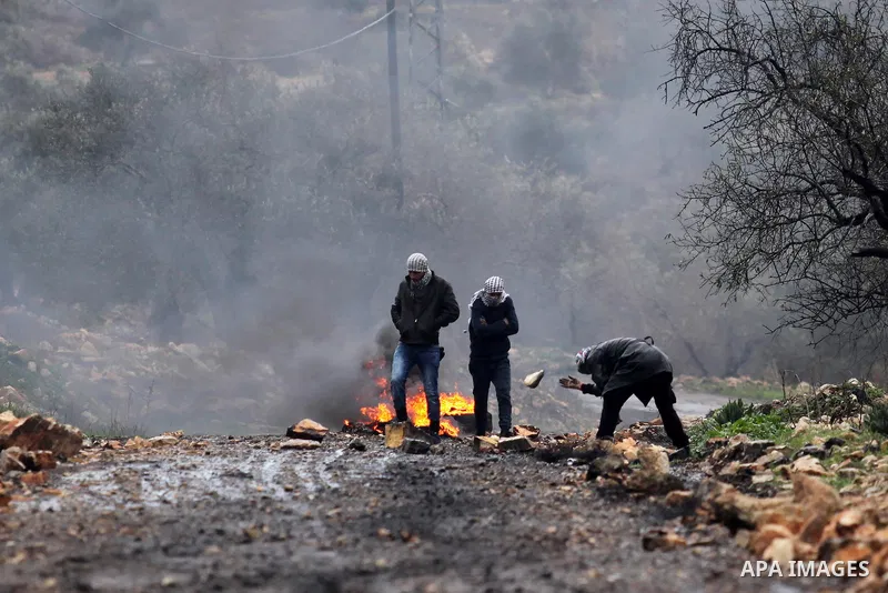 Palestinian protesters burn tires during clashes with Israeli security forces following a weekly demonstration against the expropriation of Palestinian land by Israel in the village of Kfar Qaddum, near Nablus, in the oc...