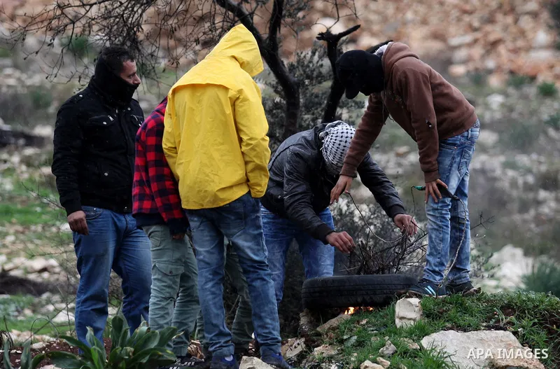 Palestinian protesters burn tires during clashes with Israeli security forces following a weekly demonstration against the expropriation of Palestinian land by Israel in the village of Kfar Qaddum, near Nablus, in the oc...