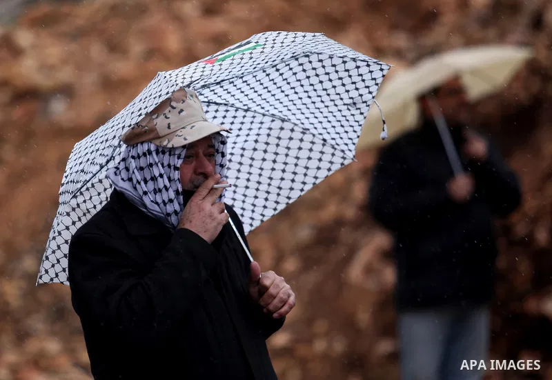 A Palestinian protester carrying an umbrella takes part in a weekly demonstration against the expropriation of Palestinian land by Israel in the village of Kfar Qaddum, near Nablus, in the occupied West Bank on January 2...