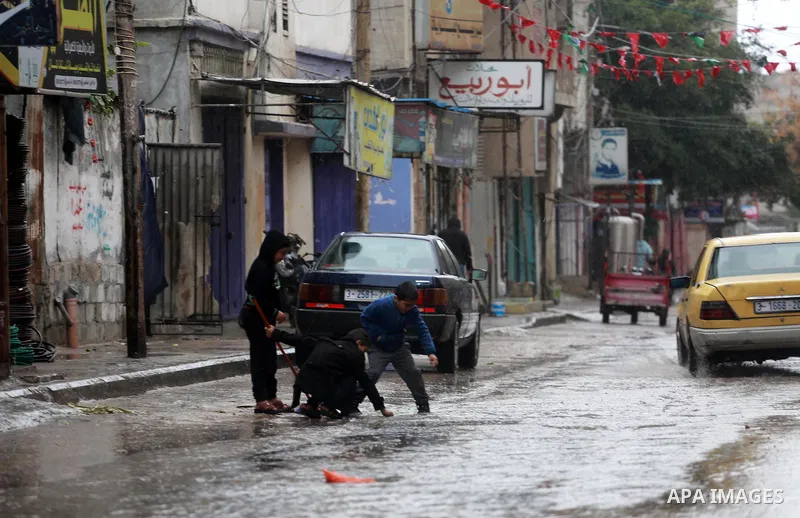 Palestinian children play at a flooded street during a rainy and heavy wind weather prevails on the Mediterranean Sea, at Shati refugee camp in Gaza City on January 28, 2017. Photo by Mohammed Asad