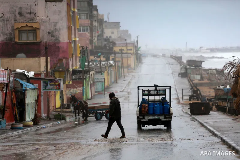 A Palestinian man walks at a flooded street during a rainy and heavy wind weather prevails on the Mediterranean Sea, at Shati refugee camp in Gaza City on January 28, 2017. Photo by Mohammed Asad