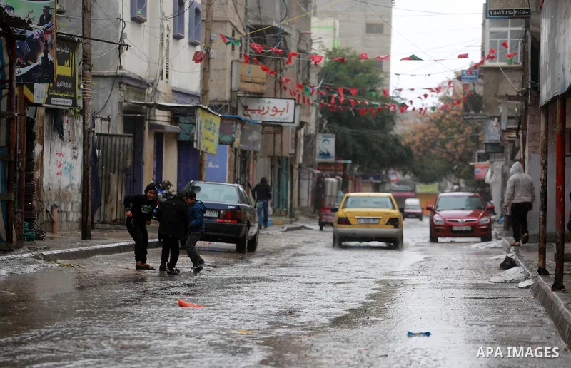 Palestinian children play at a flooded street during a rainy and heavy wind weather prevails on the Mediterranean Sea, at Shati refugee camp in Gaza City on January 28, 2017. Photo by Mohammed Asad