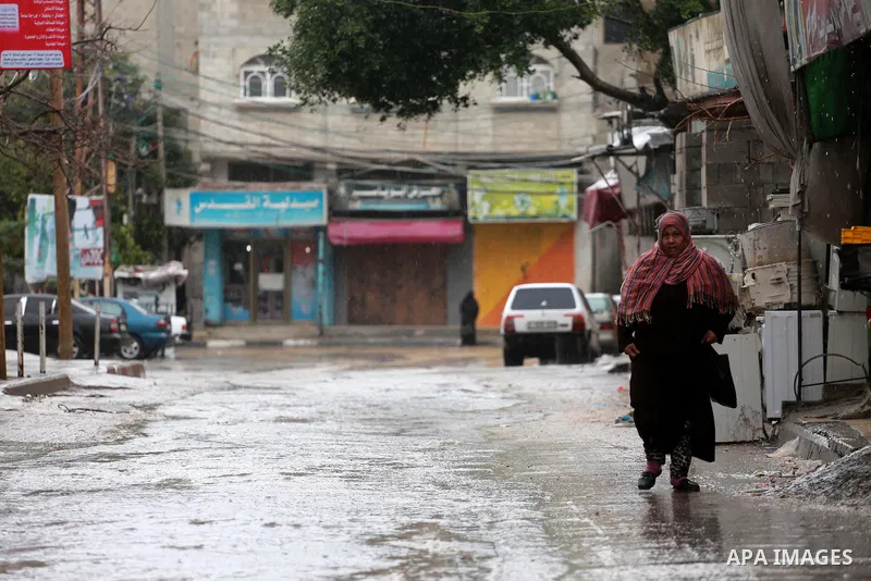 A Palestinian woman walks at a flooded street during a rainy and heavy wind weather prevails on the Mediterranean Sea, at Shati refugee camp in Gaza City on January 28, 2017. Photo by Mohammed Asad