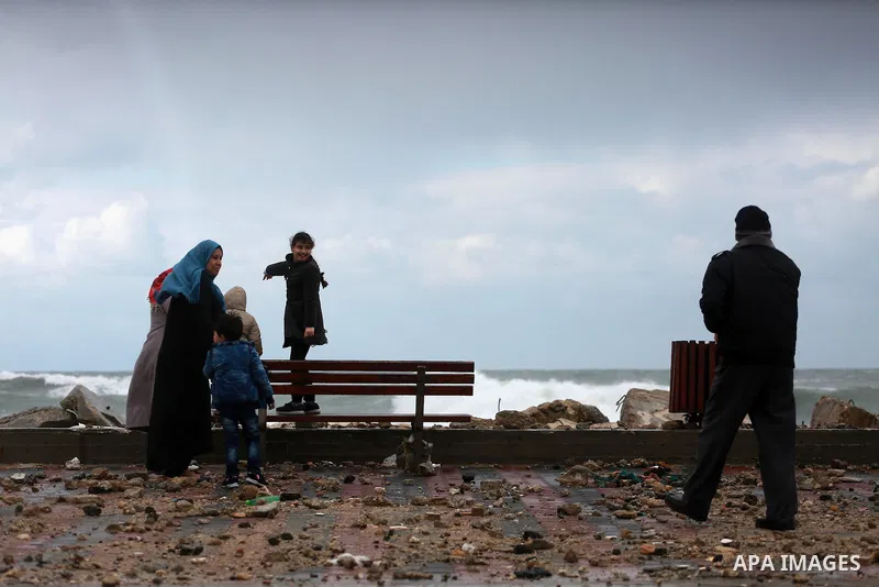 A Palestinian man takes a photo for his family at the Gaza seaport during a rainy and heavy wind weather prevails on the Mediterranean Sea, in Gaza City on January 28, 2017. Photo by Mohammed Asad