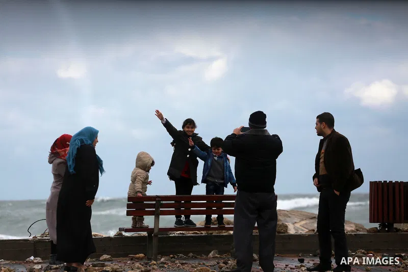 A Palestinian man takes a photo for his family at the Gaza seaport during a rainy and heavy wind weather prevails on the Mediterranean Sea, in Gaza City on January 28, 2017. Photo by Mohammed Asad