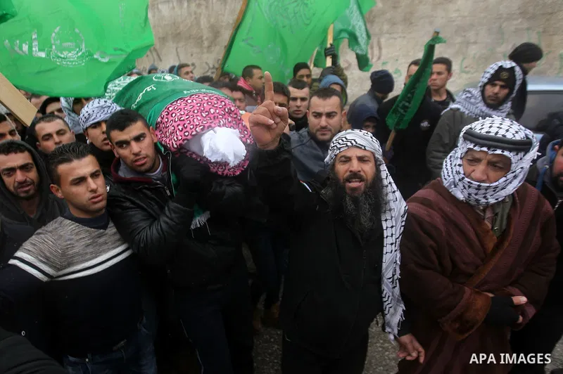 Mourners carry the shroud-wrapped body of Majd al-Khudur, a Palestinian woman who was killed by Israeli security forces during a car-ramming attack last year, during her funeral in the West Bank village of Bani Naim, nea...