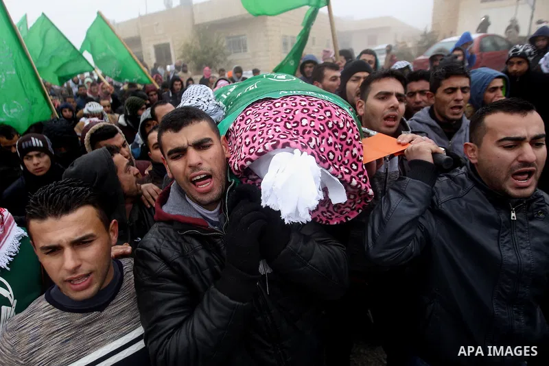 Mourners carry the shroud-wrapped body of Majd al-Khudur, a Palestinian woman who was killed by Israeli security forces during a car-ramming attack last year, during her funeral in the West Bank village of Bani Naim, nea...