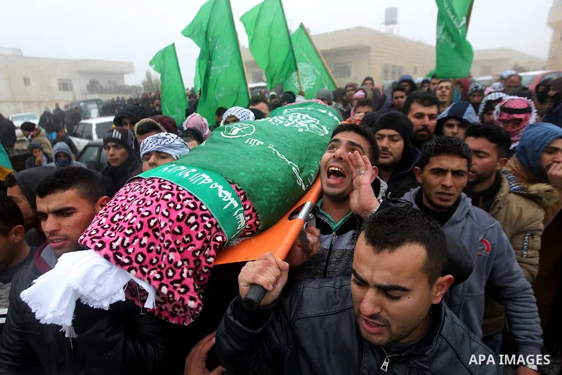 Mourners carry the shroud-wrapped body of Majd al-Khudur, a Palestinian woman who was killed by Israeli security forces during a car-ramming attack last year, during her funeral in the West Bank village of Bani Naim, nea...