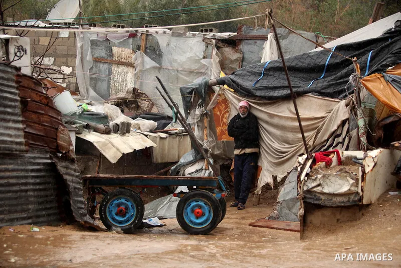 A Palestinian man stands outside a hovel during the cold and rainy weather in the Jabalia refugee camp in the northern Gaza Strip on January 28, 2017. Photo by Ashraf Amra