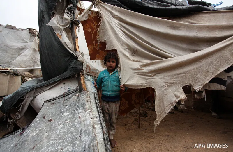 A Palestinian girl gazes outside a hovel during the cold and rainy weather in the Jabalia refugee camp in the northern Gaza Strip on January 28, 2017. Photo by Ashraf Amra