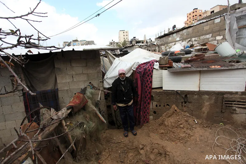 A Palestinian man stands outside a hovel during the cold and rainy weather in the Jabalia refugee camp in the northern Gaza Strip on January 28, 2017. Photo by Ashraf Amra