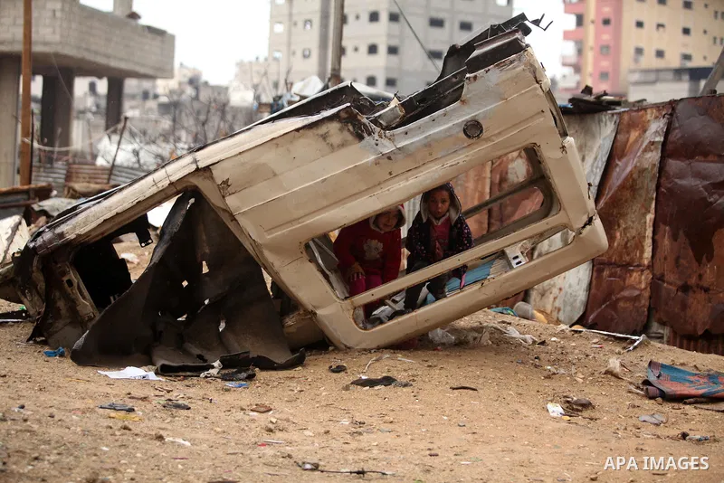 Palestinian children play outside a hovel during the cold and rainy weather in the Jabalia refugee camp in the northern Gaza Strip on January 28, 2017. Photo by Ashraf Amra