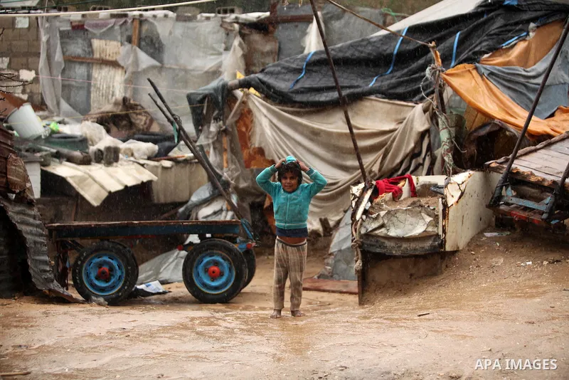 A Palestinian girl plays outside a hovel during the cold and rainy weather in the Jabalia refugee camp in the northern Gaza Strip on January 28, 2017. Photo by Ashraf Amra