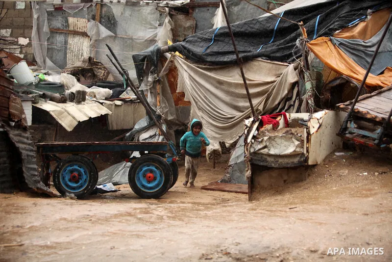 A Palestinian girl plays outside a hovel during the cold and rainy weather in the Jabalia refugee camp in the northern Gaza Strip on January 28, 2017. Photo by Ashraf Amra