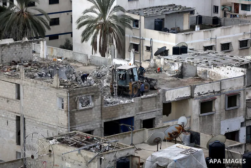Palestinian bulldozer demolishes a building house, in Gaza city, on January 29, 2017. Photo by Yasser Qudih