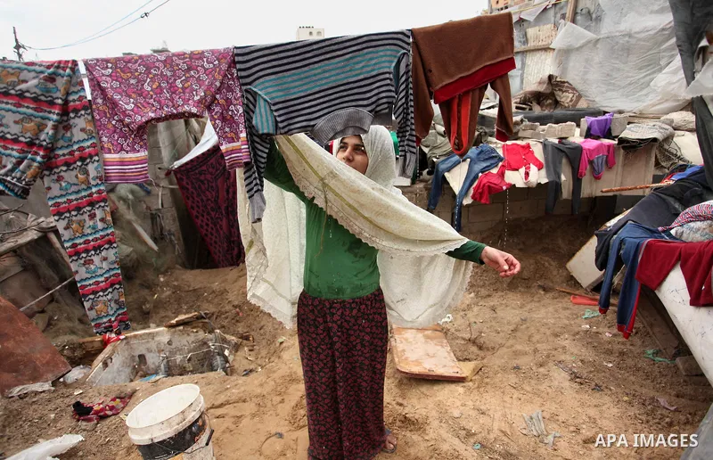 A Palestinian woman hangs laundry on a rope to dry outside her hovel during the cold weather in the Jabalia refugee camp in the northern Gaza Strip on January 29, 2017. Photo by Ashraf Amra
