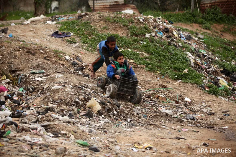 Palestinian children play outside a hovel during the cold weather in the Jabalia refugee camp in the northern Gaza Strip on January 29, 2017. Photo by Ashraf Amra