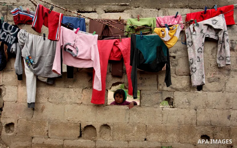 A Palestinian girl plays outside a hovel during the cold weather in the Jabalia refugee camp in the northern Gaza Strip on January 29, 2017. Photo by Ashraf Amra