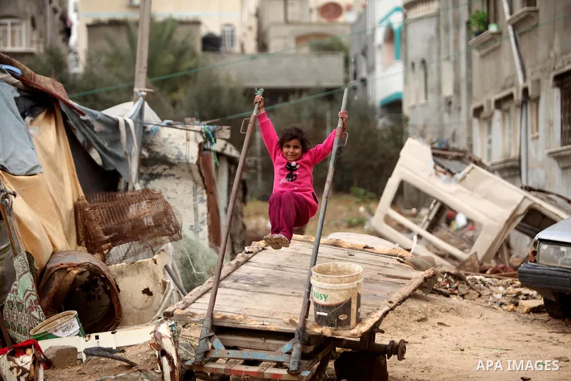 A Palestinian girl plays outside a hovel during the cold weather in the Jabalia refugee camp in the northern Gaza Strip on January 29, 2017. Photo by Ashraf Amra