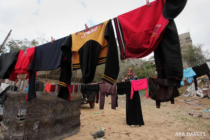 A Palestinian woman hangs laundry on a rope to dry outside her hovel during the cold weather in the Jabalia refugee camp in the northern Gaza Strip on January 29, 2017. Photo by Ashraf Amra