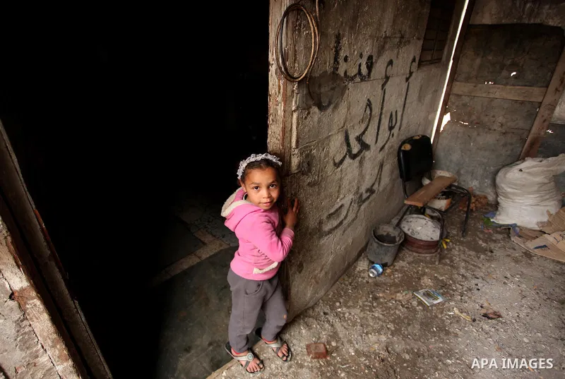 A Palestinian girl plays outside a hovel during the cold weather in the Jabalia refugee camp in the northern Gaza Strip on January 29, 2017. Photo by Ashraf Amra