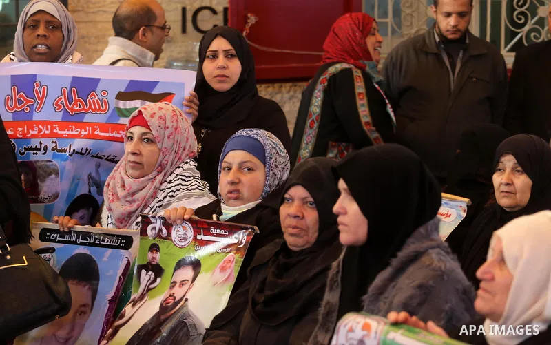 Palestinians hold placards during a protest to show solidarity with Palestinian prisoners held in Israeli Jails, in front of Red cross office in Gaza city, on January 30, 2017. Photo by Mohammed Asad