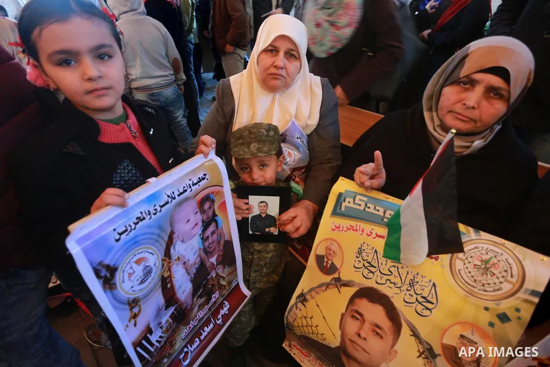 Palestinians hold placards during a protest to show solidarity with Palestinian prisoners held in Israeli Jails, in front of Red cross office in Gaza city, on January 30, 2017. Photo by Mohammed Asad
