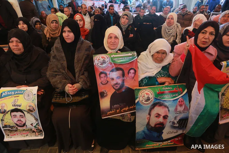Palestinians hold placards during a protest to show solidarity with Palestinian prisoners held in Israeli Jails, in front of Red cross office in Gaza city, on January 30, 2017. Photo by Mohammed Asad