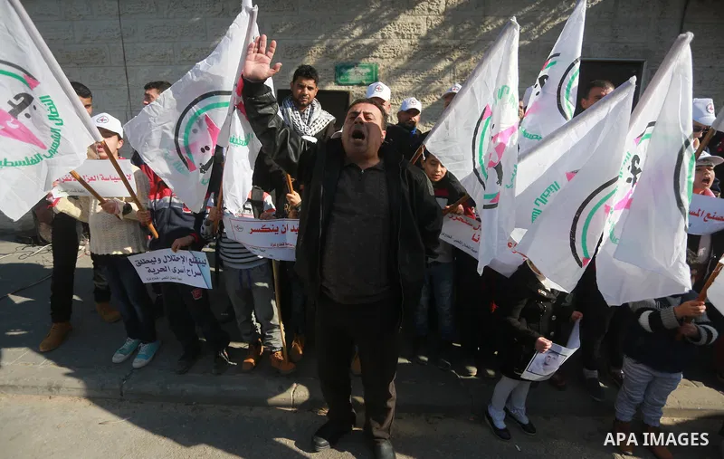 Palestinians hold placards during a protest to show solidarity with Palestinian prisoners held in Israeli Jails, in front of Red cross office in Gaza city, on January 30, 2017. Photo by Mohammed Asad