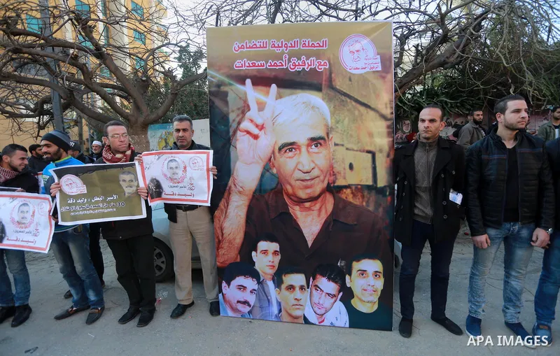 Palestinians hold placards during a protest to show solidarity with Palestinian prisoners held in Israeli Jails, in front of Red cross office in Gaza city, on January 30, 2017. Photo by Mohammed Asad